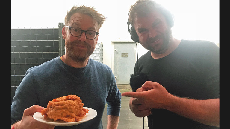 Christian Schmitt und Paulus Müller essen frittierten Burger
