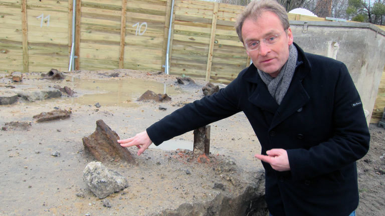 Torsten Dressler, Archäologe steht an einer Baustelle mit Resten der Berliner Mauer.