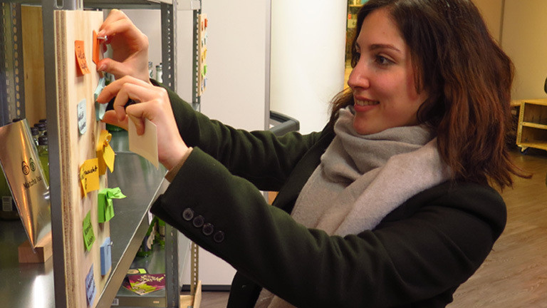 Junge Frau bewertet Start-Up-Produkte im Testsupermarkt in Berlin.