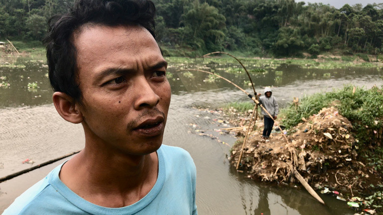 Der Fischer Yayang Kaleng versucht im Fluss Citarum zu angeln.