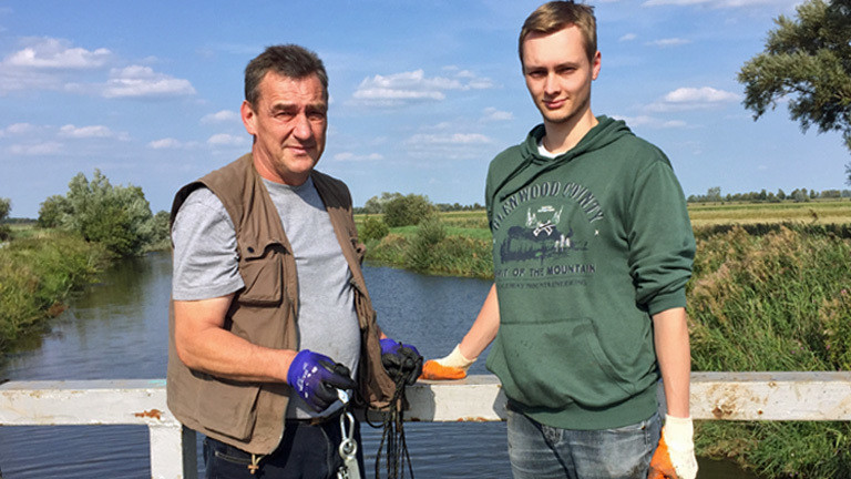 Magnetangler Wolfgang (60) und Lukas (24) auf einer Brücke in Schleswig-Holstein