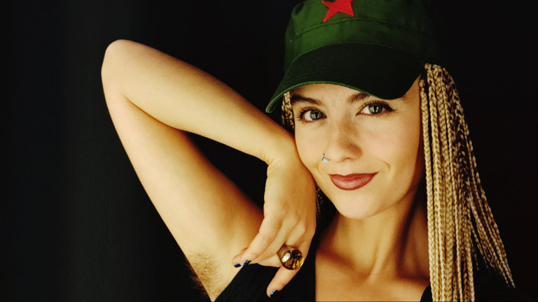 Kristina Lang hebt den Arm, um ihre behaarte Achselhöhle zu zeigen.