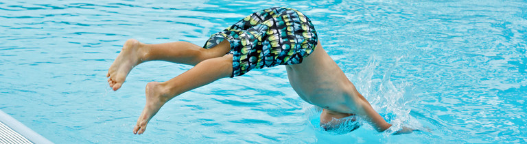 Mann springt in Pool.
