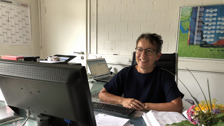 Frau sitzt vor Computer.