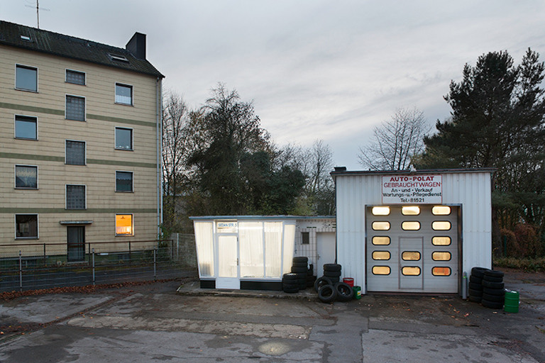 Hinterhof mit Wellblech-Garage und kleinem Tankstellen-Häuschen