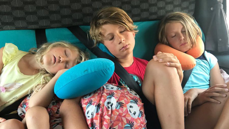 Liv, Paul und Fannie sitzen auf der Rückbank eines Bullis während sie mit ihren Eltern Europa durchqueren.