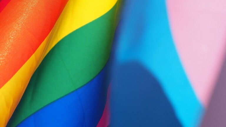 Die Regenbogenfahne weht in der Luft.