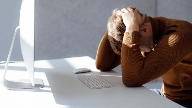 Ein Mann hat die Hände über den Kopf geschlagen.