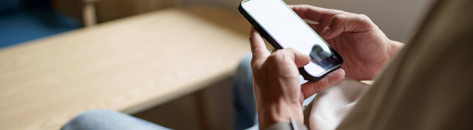 Ein Jugendlicher schaut auf sein Handy.