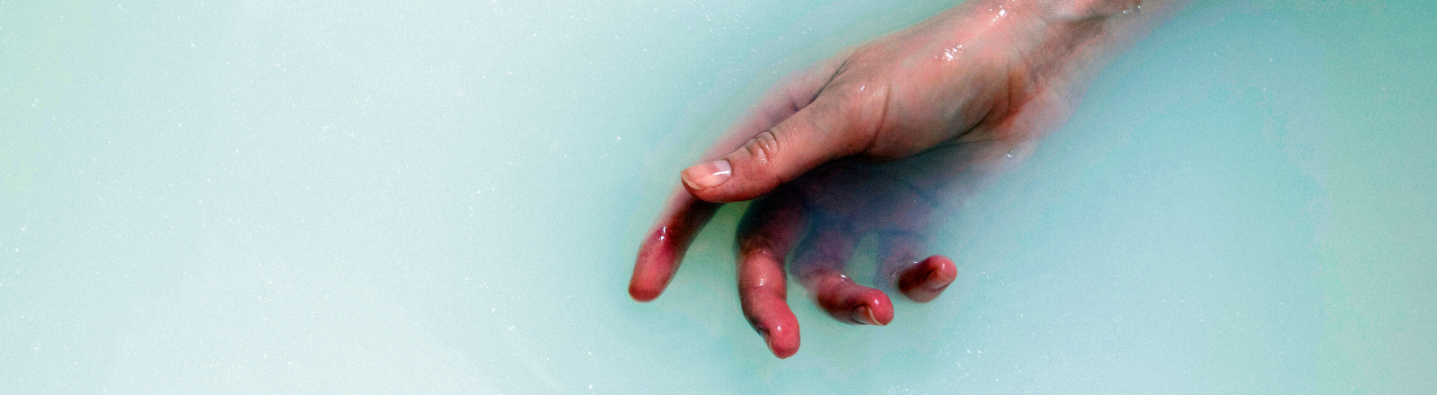 Eine Hand und ein Arm werden teilweise ins Wasser getaucht.