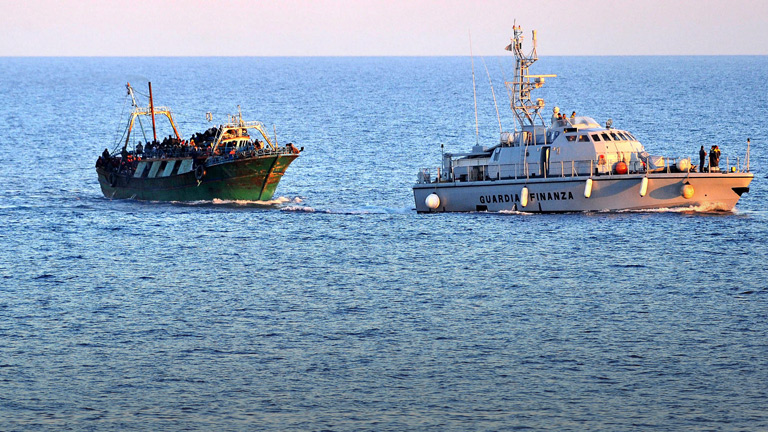 Ein Flüchtlingsschiff wird von der italienischen Finanzwache begleitet.