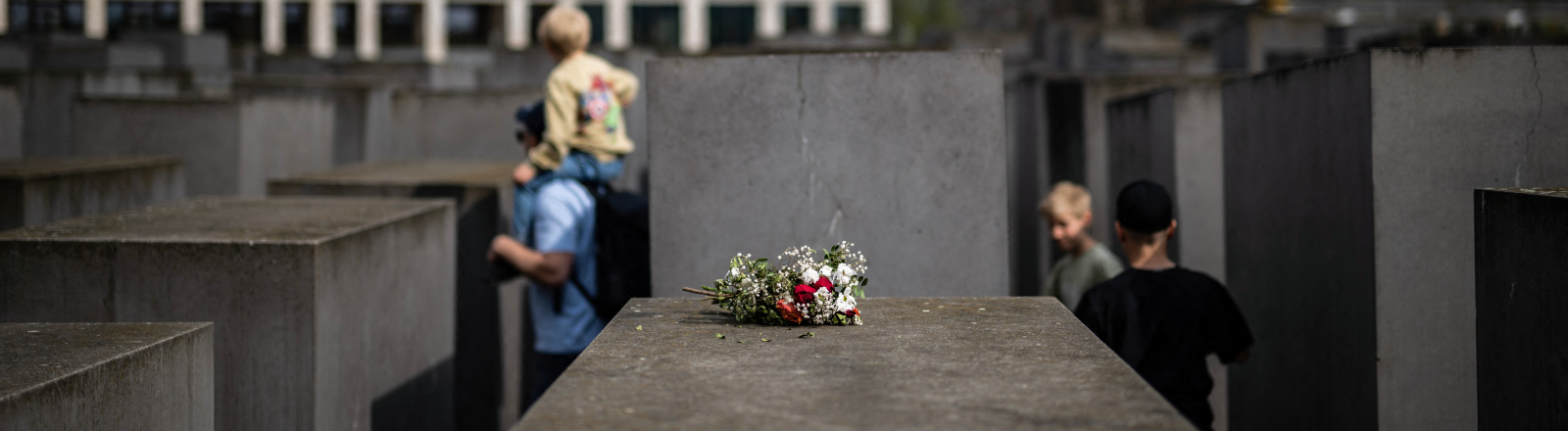 Ein Blumenstrauß liegt im April 2025 auf dem Denkmal für die ermordeten Juden Europas in Berlin