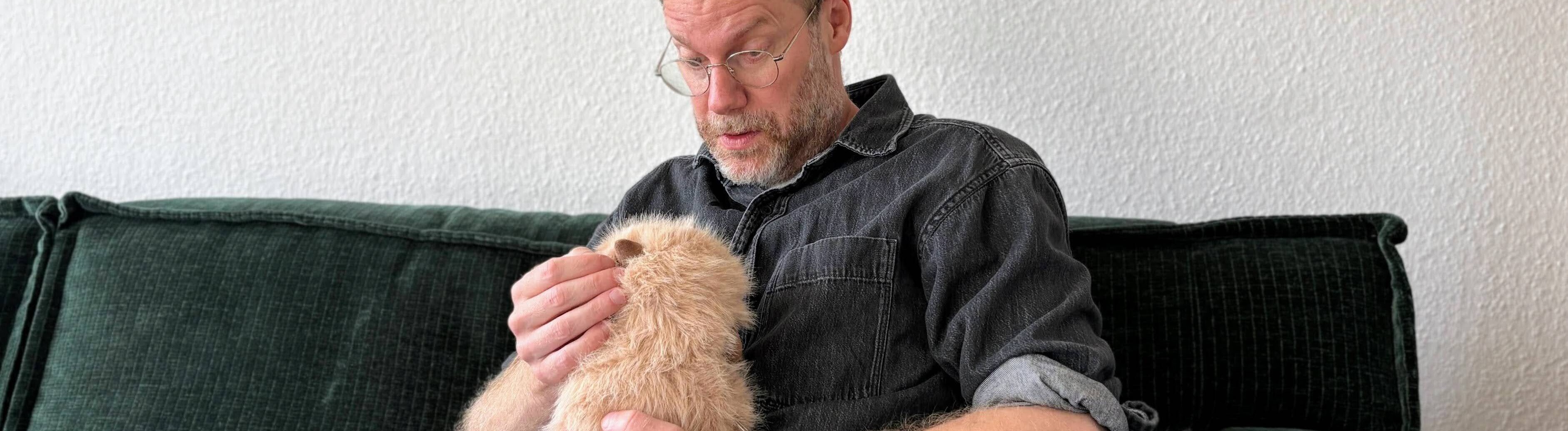 Reporter und Radioautor Christian Schmitt hält ein KI-Kuscheltier auf dem Arm