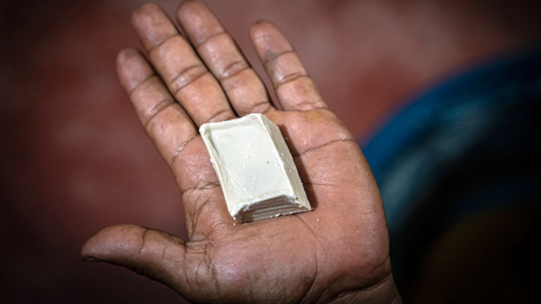 Ein Mann zeigt ein Stück Kokapaste am Rande einer Koka-Plantage, wo Kokablätter zu Paste verarbeitet werden.