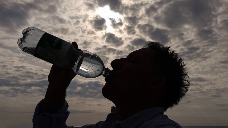 Mann trinkt Wasser aus einer Plastikflasche.