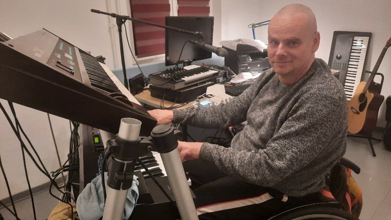 Perry Walczok sitzt im Rollstuhl vor einem Keyboard.