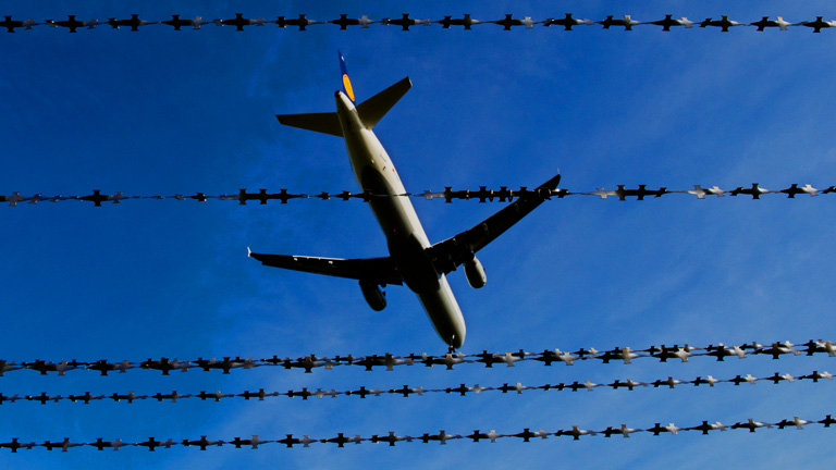 Ein Flugzeug fliegt 26.10.2015 am Flughafen in Hannover (Niedersachsen) hinter Stacheldraht (Symbolbild zum Thema Abschiebung).