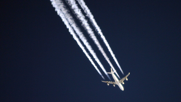 Flugzeug am Himmel mit Kondensstreifen