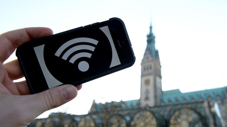 Ein WLAN-Symbol auf einem Smartphone vor dem Rathaus in Hamburg