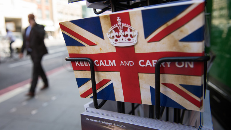 Eine Postkarte mit dem britischen Spruch "Keep calm and carry on" im Ständer.