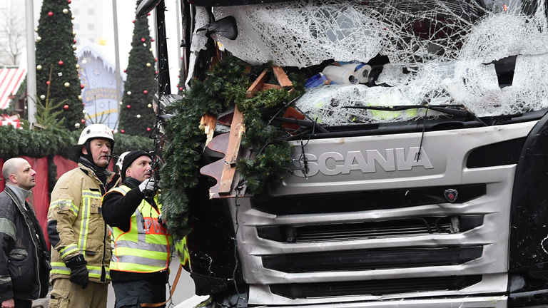 Rettungsleute begutachten den beschädigten Sattelschlepper, der am Montag in einen Weihnachtsmarkt gerast ist.