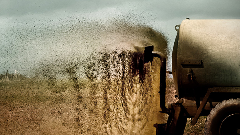 Gülle wird auf einem Feld verteilt.