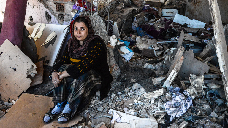 Eine Frau sitzt in ihrem zerstörten Haus in Cizre, im Südosten der Türkei.