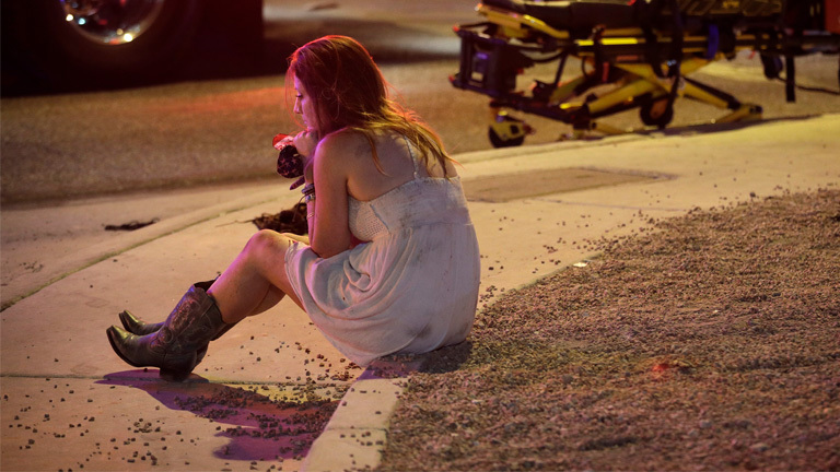 Eine Konzertbesucherin sitzt nach dem Schusswaffen-Angriff am 02.10.2017 in Las Vega, nahe des Mandalay Bay Resort und Casinos.