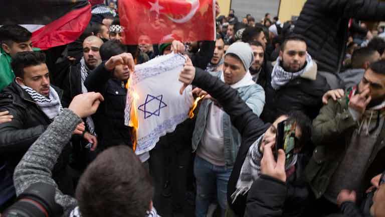 Menschen verbrennen eine jüdische Fahne in Berlin