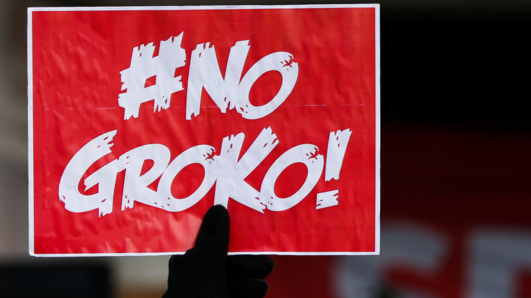 Ein Juso hält am 21.01.2018 ein Schild mit der Aufschrift "#NoGroko!" bei einer Demonstration vor dem WCCB beim außerordentlichen SPD-Parteitag in Bonn (Nordrhein-Westfalen). Die Delegierten stimmen bei ihrem Bundesparteitag darüber ab, ob die SPD in Koalitionsverhandlungen mit der Union einsteigt.