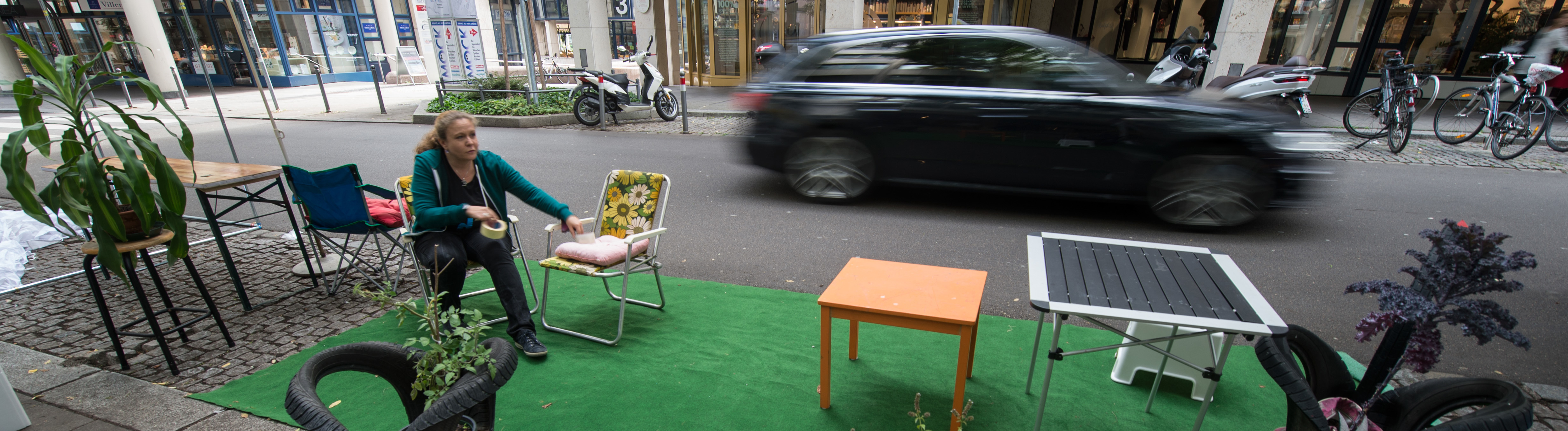 Eine Aktivistin der Initiative "Park(ing Day" arbeitet am 18.09.2015 in Stuttgart (Baden-Württemberg) an einem Mini-Park, der spontan und provisorisch für einen Tag auf einem Parkplatz entsteht.