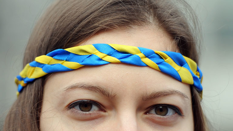 Einen Frau trägt am 02.03.2014 vor der russischen Botschaft in Berlin einen Kranz mit den Nationalfarben der Ukraine auf dem Kopf.