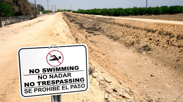 Ein Schild in Kalifornien, das das Schwimmen in einem Kanal verbietet.