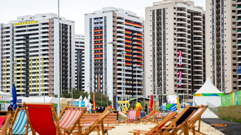 Das olympische Dorf in Rio, davor Liegestühle am Strand.