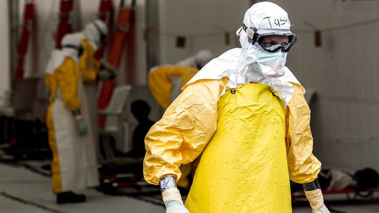 Eine Person ist komplett in Schutzkleidung gekleidet, um sich vor dem Ebolavirus zu schützen.