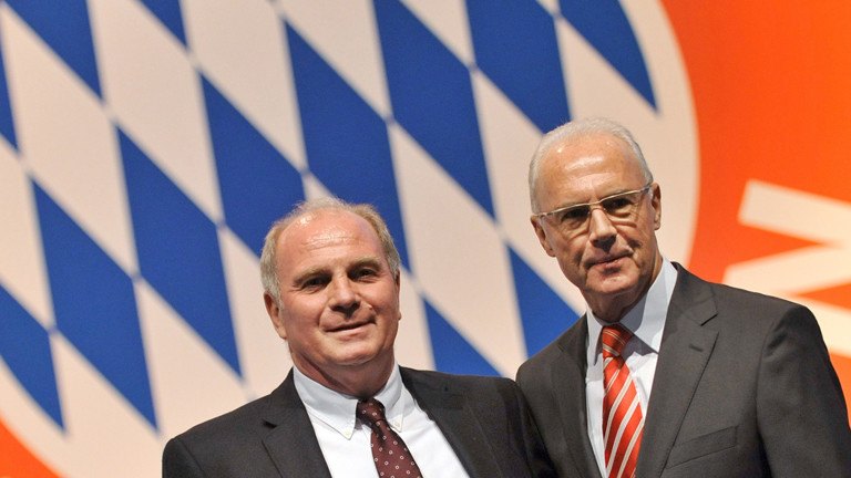 Manager Uli Hoeneß (l) und Präsident Franz Beckenbauer vom Fußball-Bundesligisten FC Bayern München stehen am Freitag (27.11.2009) auf der Jahreshauptversammlung in München (Oberbayern) vor dem Vereinslogo.