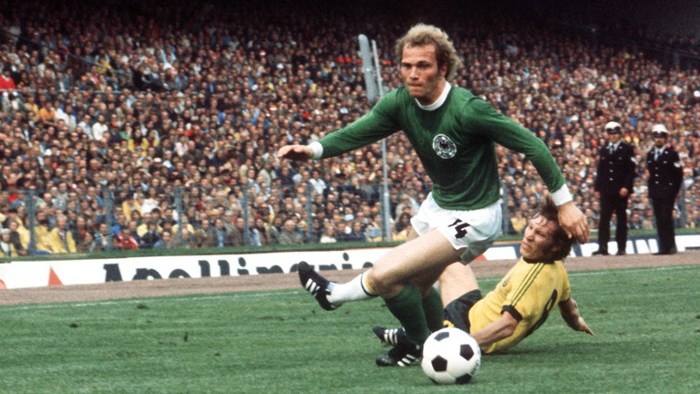 Der deutsche Mittelfeldspieler Uli Hoeneß (vorn) kommt vor dem australischen Mittelfeldakteur James Mackay an den Ball. Die deutsche Fußballnationalmannschaft gewinnt am 18.06.1974 vor 53.300 Zuschauern im Hamburger Volksparkstadion das WM-Gruppenspiel gegen Australien mit 3:0.