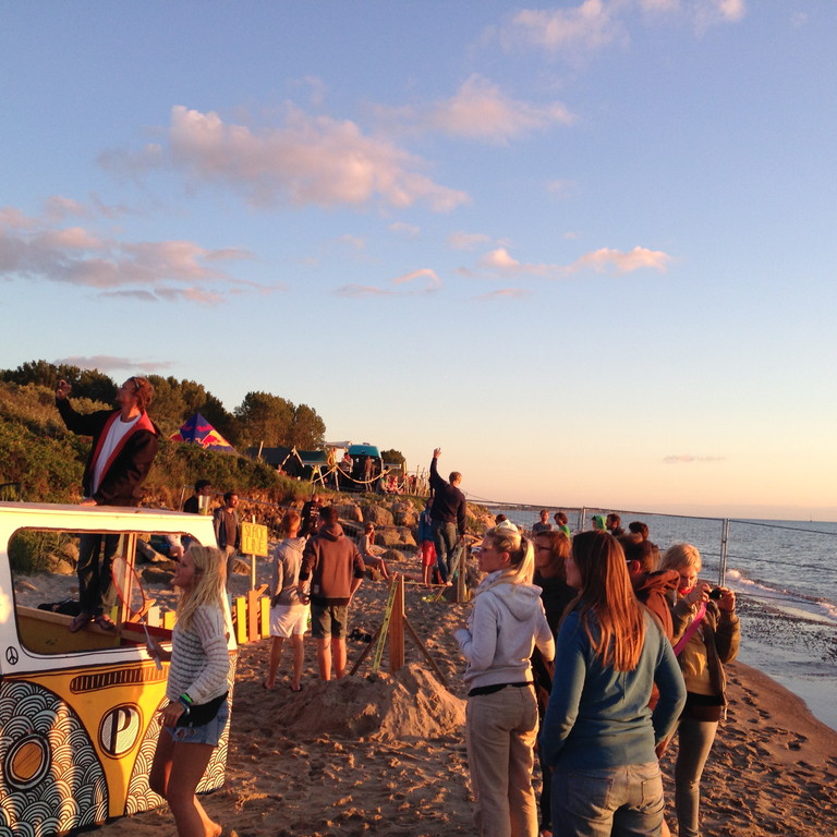 Menschen stehen an der Ostsee bei Sonnenuntergang