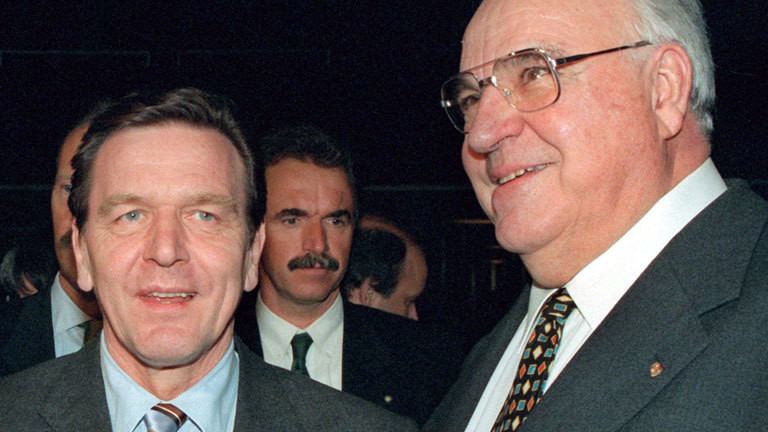 Bundeskanzler Helmut Kohl (r) und Niedersachsens Ministerpräsident Gerhard Schröder begegnen sich am 18.3.1998 bei der Eröffnungsfeier der CeBIT-Messe in Hannover. In seiner Eröffnungsrede zur weltgrößten Computermesse kritisierte Kohl die Steuervorschläge des SPD-Wahlprogramms als völlig unzureichend. Ohne die SPD zu nennen, bezeichzete er eine Senkung des Spitzensteuersatzes von 53 auf 49 Prozent als bedeutungslos. Notwendig sei eine wesentlich stärkere Senkung des Spitzensteuersatzes nach dem Vorbild europäischer Nachbarländer.