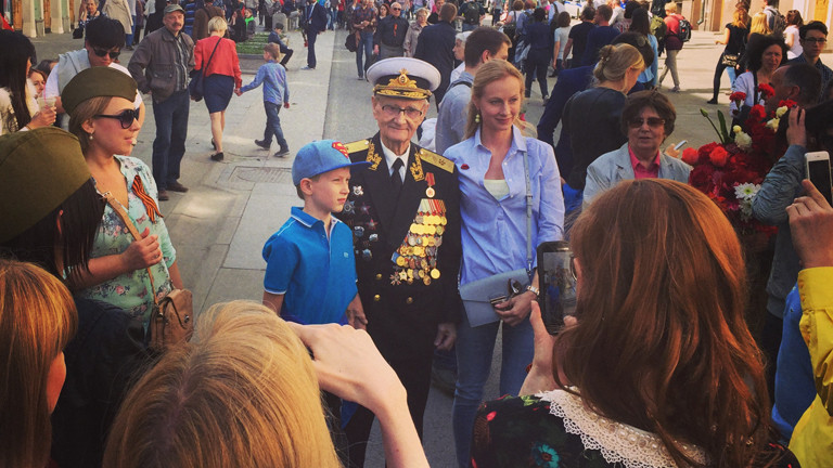 Ein alter Mann in Uniform, über und über behängt mit Orden, neben ihm ein kleiner Junge.