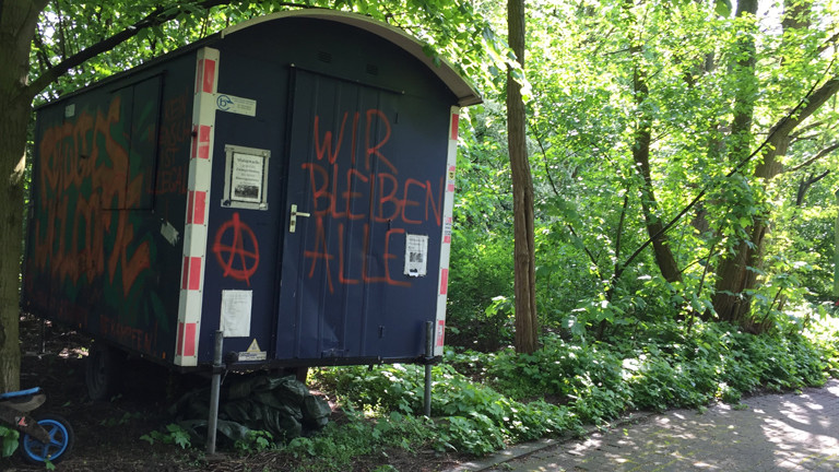 Bauwagen mit der Aufschrift "Wir bleiben alle"