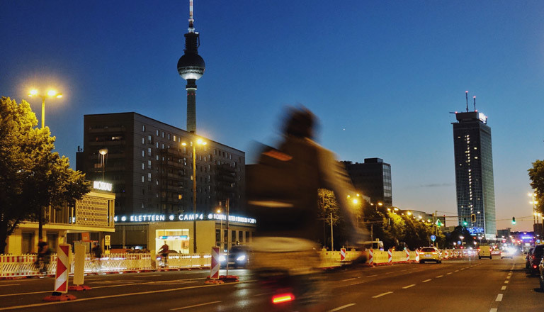 Berlin, Fahrradfahrer am Abend auf der Karl-Marx-Allee