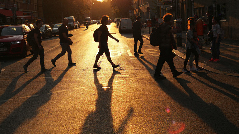 Fußgänger, die eine Straße überqueren - im Abendlicht.