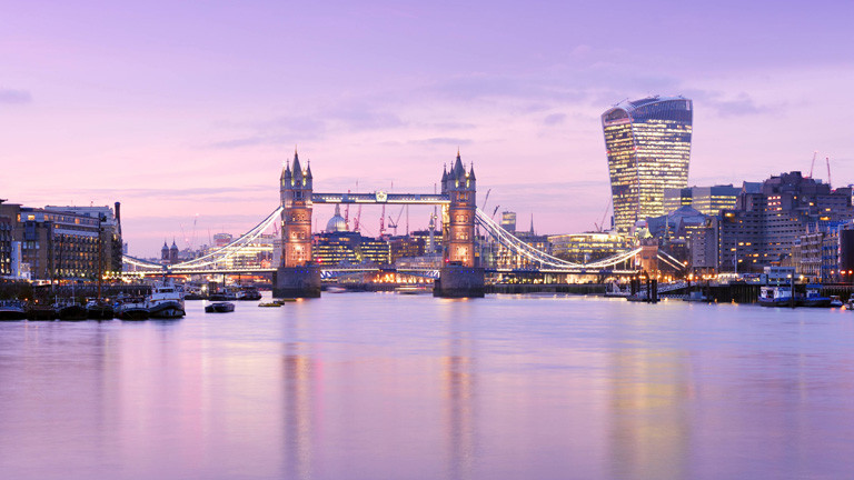 Skyline von London am Abend mit Themse und Tower Bridge.