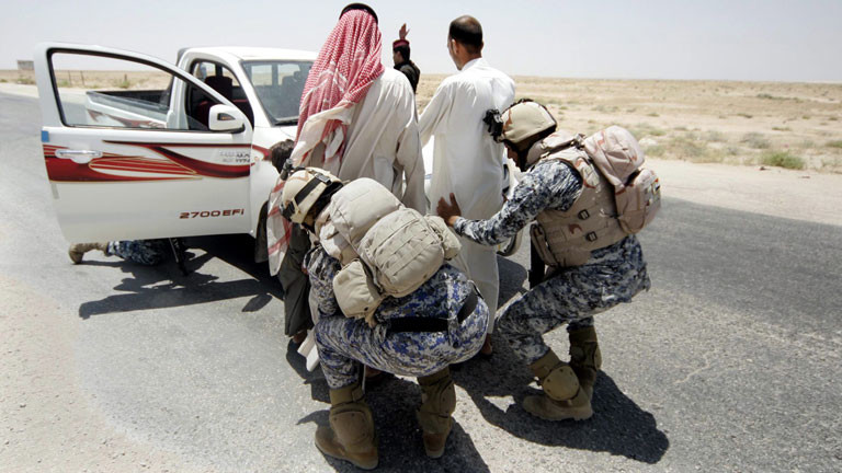 Irakische Soldaten tasten Passanten an einem Checkpoint zwischen Karbala und Ramadi ab.