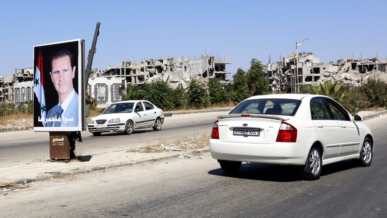 DPA: Assad Poster auf einer Straße im zerbombten Homs.