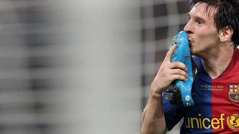 Fußballer Messi küsst seinen Fußballschuh.