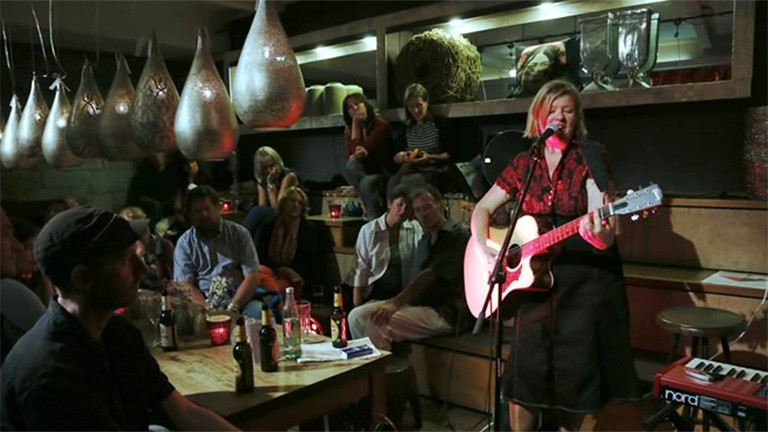 Hanna Fearns steht auf der Bühne und spielt Gitarre.