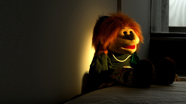 Eine Handpuppe auf einem Bett