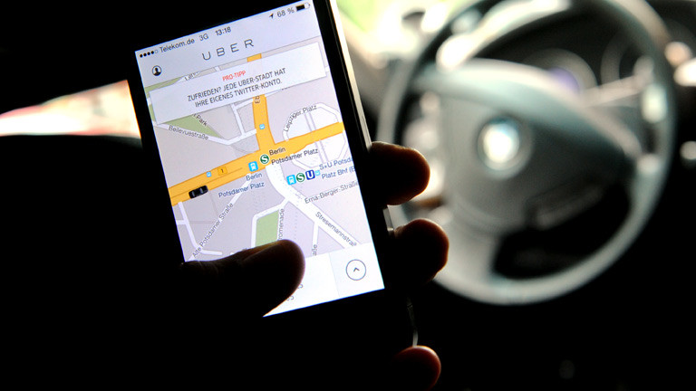 Jemand hält in seiner Hand ein Smartphone, auf dem die Uber-App aufgerufen ist.